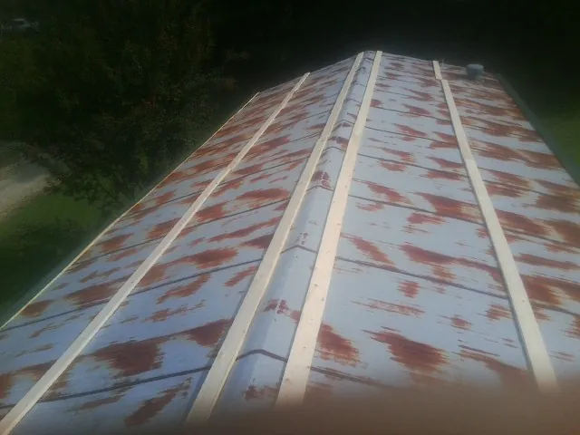 Rusted metal roof panels with new wood purlins before replacement — Storm Damage Roof Repair in Crystal Beach by Roofing Brothers