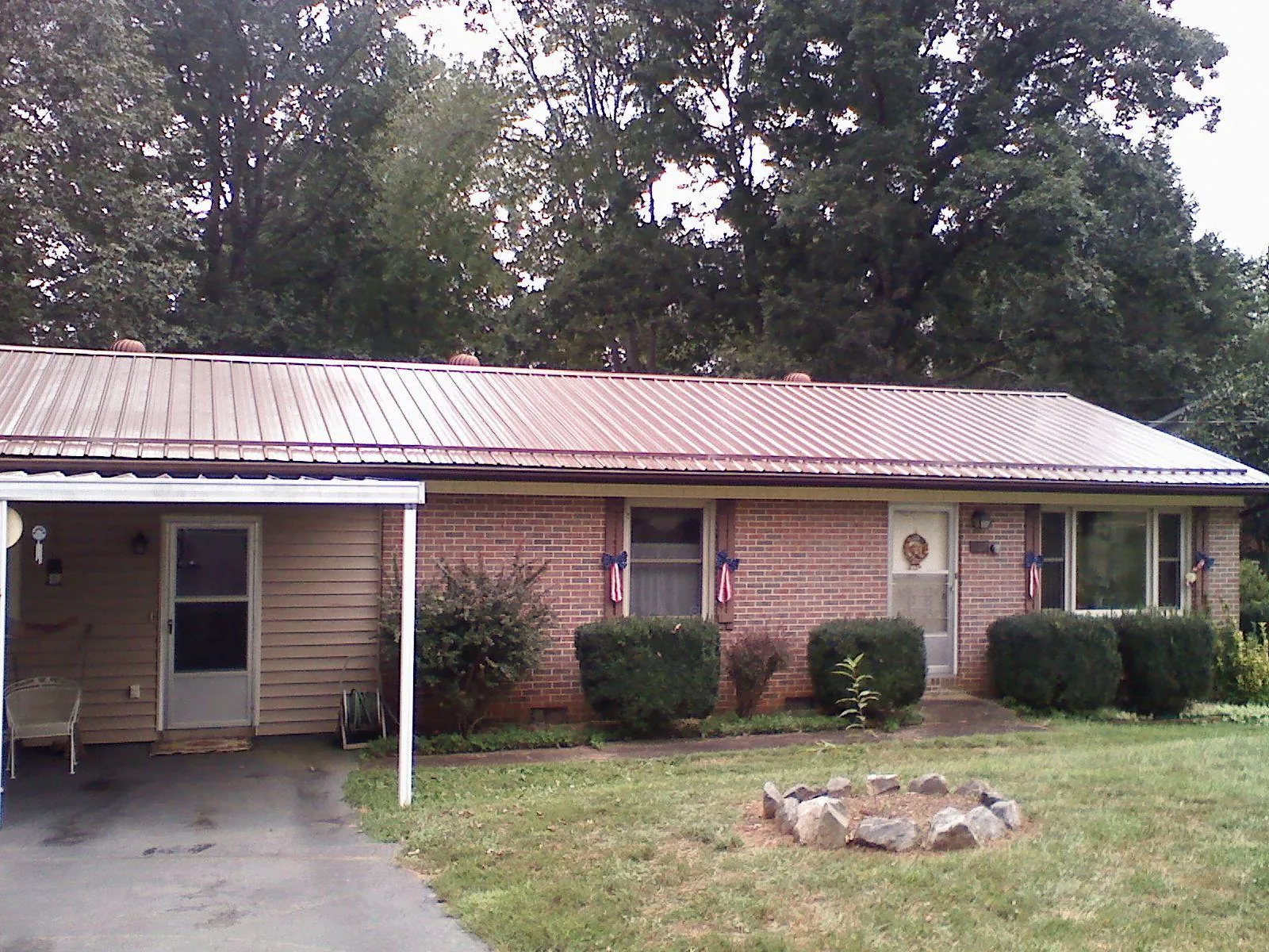 Bronze metal roof and carport on a brick ranch home — Roof Repair work by our crew in Crystal Beach
