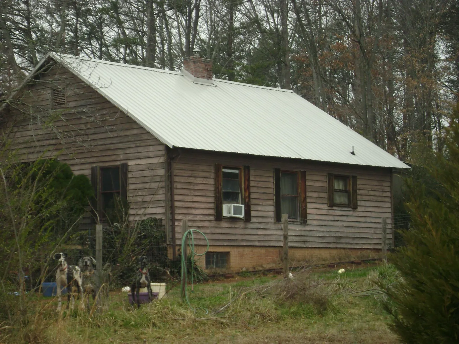 White metal roof on an old wood sided farmhouse, from a Metal Roof Installation job in Crystal Beach